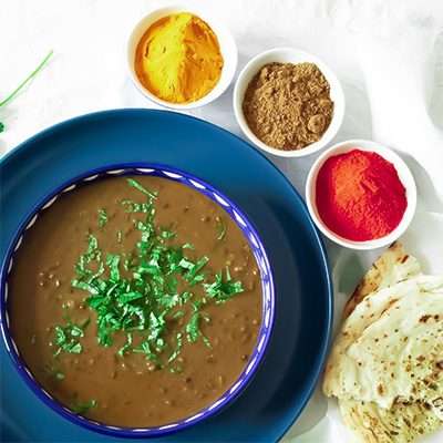 Display of spices essential for easy curry including chilli powder, turmeric and garam masala. Surround bowl of daal.